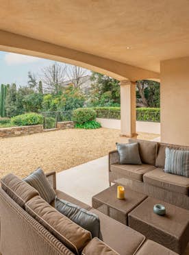 location - Pampres - Modern outdoor terrace with garden view  location - Pampres - This image shows a modern outdoor terrace with a comfortable lounge area offering a stunning view of a well-maintained garden. The space is perfect for relaxation and evening outdoors.