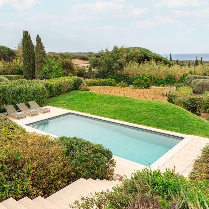 location - Pampres - Pool with stunning nature view  location - Pampres - This image shows a private pool surrounded by lush gardens with a stunning view of nature and the sea in the distance. Perfect for relaxation and well-being.