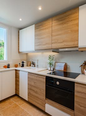 location - Sienna - Modern Kitchen with Natural Light  location - Sienna - This modern kitchen features light wood cabinets and built-in appliances. Natural light from the large window creates a warm and inviting atmosphere.