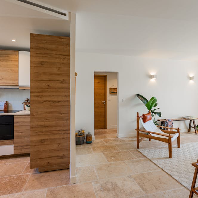 location - Sienna - Modern dining area and open kitchen  location - Sienna - This image shows a modern dining area with an open kitchen, wooden furniture, and elegant decorative elements.