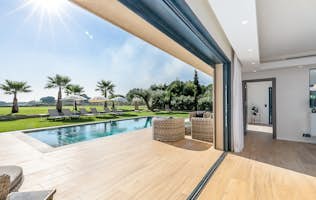 location - Belle des Marres - Panoramic View of Pool and Garden  location - Belle des Marres - Image of a modern home with a panoramic view of a pool and lush garden. The home features contemporary design elements with a large glass door offering a stunning view of the outside.