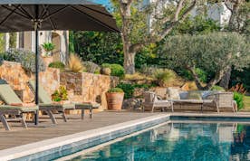 location - Albelia - Modern Outdoor Pool and Terrace  location - Albelia - Discover this stunning outdoor pool with a wooden terrace and elegant garden furniture, surrounded by lush greenery.
