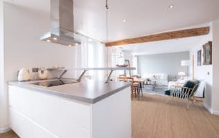 location - Paula - Modern and Bright Kitchen  location - Paula - This modern and bright kitchen features a quartz countertop island, built-in range hood, and high-end appliances. It opens up to a cozy living space with a living room and dining area.
