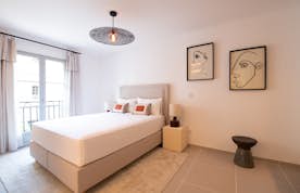 location - Oscar - Modern Bedroom with Balcony  location - Oscar - Modern bedroom featuring a large bed, wall art, and a balcony with an outdoor view.