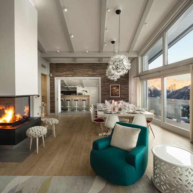 location - POW POW - Modern dining room with fireplace and panoramic view  location - POW POW - This modern dining room offers a cozy atmosphere with a central fireplace and a stunning mountain view. Perfect for family meals or gatherings with friends.