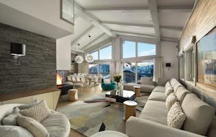 location - POW POW - Modern living room with panoramic view  location - POW POW - A modern living room with a panoramic view of the mountains, a fireplace, and designer furniture.