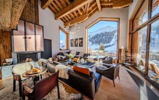 location - ORSO  - Modern living room with panoramic mountain view  location - ORSO  - This modern living room offers a stunning view of the snow-covered mountains. The space is warm and inviting with high-quality furniture and large windows that let in plenty of natural light.