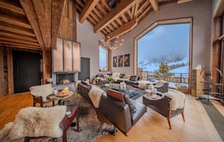 location - ORSO  - Modern living room with panoramic view  location - ORSO  - A modern living room with a panoramic view of snow-covered mountains. Decorated with leather furniture and fur throws, this space is perfect for relaxing.