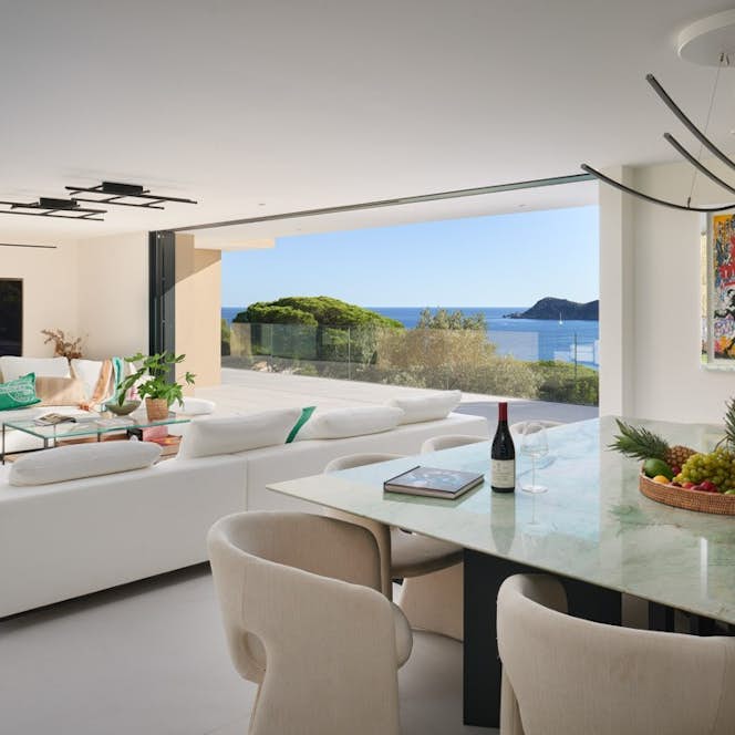 location - Casabianca - Modern dining room with sea view  location - Casabianca - This modern dining room offers a stunning sea view. It is furnished with contemporary furniture and a large glass table.
