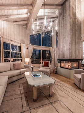 accommodation - Edelstone  - Modern living room with fireplace and large windows  accommodation - Edelstone  - A spacious and modern living room with a central fireplace, large windows offering a stunning view, and elegant furniture.