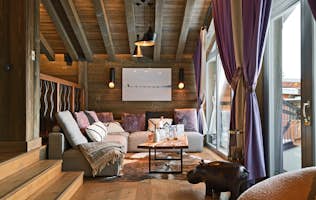 accommodation - Labaobou - Modern living room with wooden decor  accommodation - Labaobou - A modern living room with warm wooden decor, comfortable sofas, and a large window offering an outdoor view. The space is adorned with colorful cushions and a wooden coffee table.