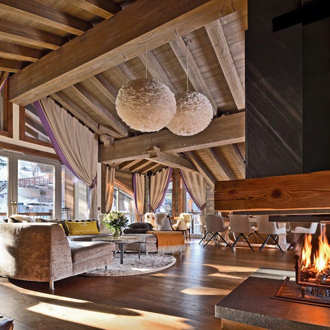 accommodation - Labaobou - Modern living room with fireplace and large windows  accommodation - Labaobou - This modern living room features an elegant design with a central fireplace, large windows offering a stunning view, and comfortable furniture. The warm ambiance is enhanced by wooden beams and sophisticated lighting.