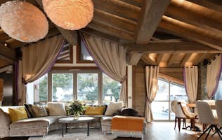 accommodation - Labaobou - Modern living room with elegant wooden decoration  accommodation - Labaobou - This image shows a modern living room with elegant wooden decoration. The room is well-lit with hanging lamps and large windows offering a view of the outside.