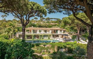 location - Faune - Luxury Home with Pool and Garden  location - Faune - Beautiful luxury home with a pool and lush garden, surrounded by trees and greenery.