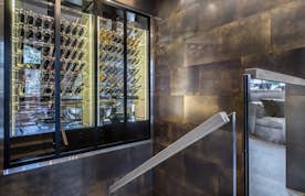 accommodation - La Datcha  - Modern and elegant wine cellar  accommodation - La Datcha  - This modern and elegant wine cellar features an impressive collection of wine bottles, neatly stored in a glass cabinet with integrated lighting. The warm and inviting atmosphere is perfect for wine enthusiasts.