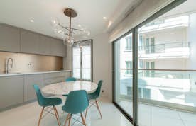 location - Croisette - Modern dining room with city view  location - Croisette - This image shows a modern dining room with a marble table, designer chairs, and a stunning city view.