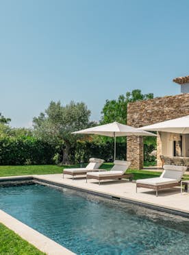 location - Avalon - Luxurious Villa Pool and Garden  location - Avalon - Image of an outdoor pool with lounge chairs and umbrellas in a lush garden. Perfect for relaxation and leisure time.