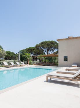 location - Amour - Luxurious Villa Pool and Terrace  location - Amour - Image of an outdoor pool with lounge chairs and a view of palm trees, perfect for relaxation.