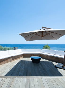 location - Enalios - Terrace with sea view  location - Enalios - Wooden terrace with modern furniture offering a stunning sea view.
