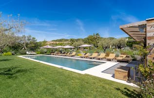 location - Deso - Luxurious Pool and Garden with Relaxation Furniture  location - Deso - Discover this beautiful pool surrounded by a lush garden with lounge chairs and umbrellas for optimal relaxation.