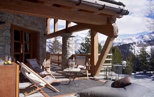 location - Les Sorbiers  - Wooden Terrace with Mountain View  location - Les Sorbiers  - Wooden terrace with comfortable furniture offering a stunning view of snow-capped mountains.