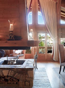 location - Les Sorbiers  - Modern living room with stone fireplace  location - Les Sorbiers  - A modern living room with a stone fireplace, comfortable sofas, and elegant decor. The space is warm and inviting, perfect for relaxing.