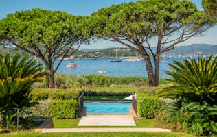location - Canoubwest - Panoramic Sea View from the Pool  location - Canoubwest - Enjoy this stunning sea view from the pool, surrounded by lush greenery and palm trees. Perfect for ultimate relaxation.