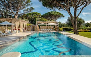 location - Canoubwest - Modern outdoor pool with pergola  location - Canoubwest - This image shows a modern outdoor pool with a pergola, lounge chairs, and surrounding trees. The space is perfect for relaxing and enjoying the nice weather.