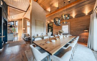 accommodation - Arpont  - Modern dining room with elegant wood decor  accommodation - Arpont  - This image shows a modern dining room with an elegant wood decor. The room is furnished with a large wooden table surrounded by comfortable chairs. The walls and ceiling are adorned with wood, and modern lighting fixtures add a touch of sophistication.