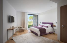 location - Haroma - Modern Bedroom with Garden View  location - Haroma - This modern bedroom offers a stunning view of the garden. It is equipped with a large bed, a flat-screen TV, and elegant furniture.