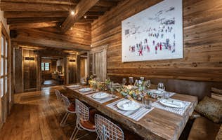 accommodation - IMA  - Rustic Dining Room with Elegant Decoration  accommodation - IMA  - This rustic dining room features elegant decoration with wooden walls and a beautifully set table for a meal. The warm and inviting atmosphere makes it a perfect space for family or friends gatherings.